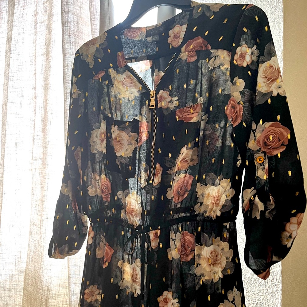 Sheer black blouse. Gold zipper detail. Floral pattern.
